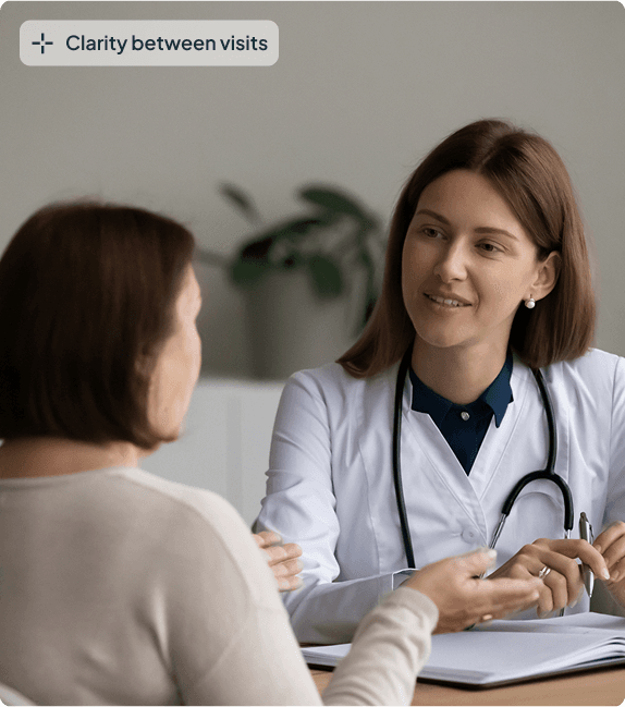 Clinician in teal scrubs at a computer with a patient, with a Clarity between visits label